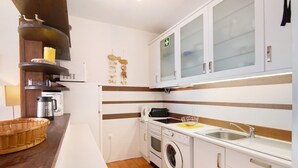 Una cocina funcional con lavadora, lavaplatos y estufa.