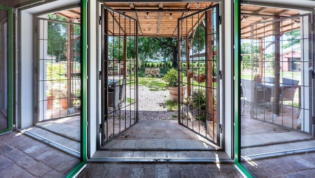 A covered outdoor area with a gravel path, potted plants, and a table and chairs. - Villa 'All'ombra Della Quercia' with Private Pool, Wi-Fi and Air Conditioning (Fano)