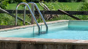A swimming pool with metal ladders, surrounded by a fence and greenery. - Villa 'All'ombra Della Quercia' with Private Pool, Wi-Fi and Air Conditioning (Fano)