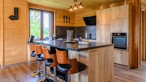 Ein Holzinterieur mit Barbereich, Küche und einem Essbereich.