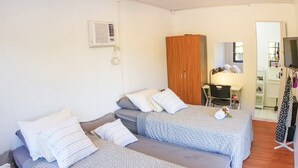 Une chambre avec deux lits, un bureau et une armoire.