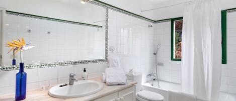Une salle de bain avec un lavabo, des toilettes et une baignoire.