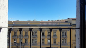 Un edifici groc amb un balcó i un cel blau clar.