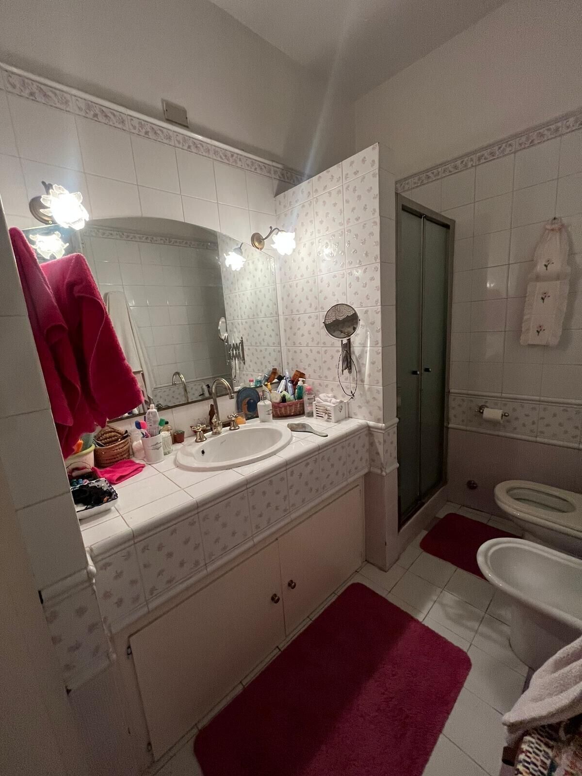 Ein Badezimmer mit Doppelwaschbecken, Spiegel, Dusche und Toilette.