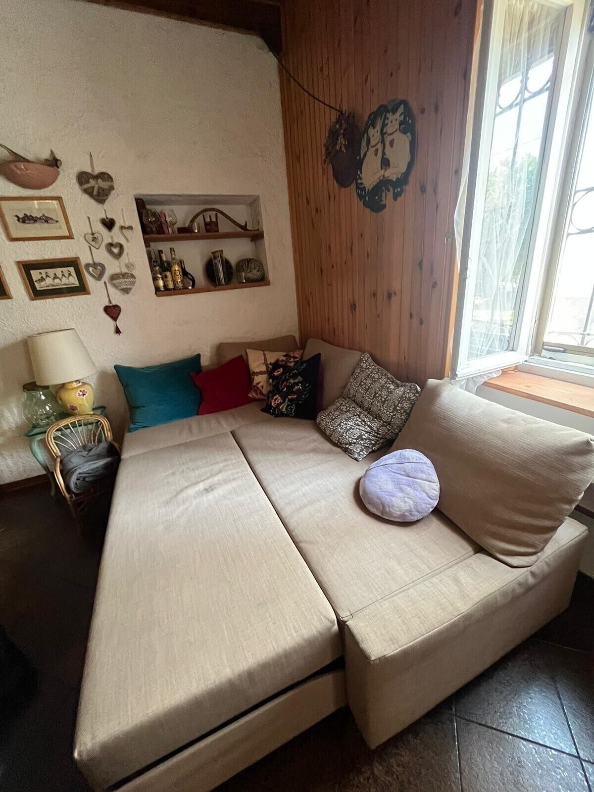 Un salon chaleureux avec un canapé, une petite table et des éléments décoratifs sur les murs.