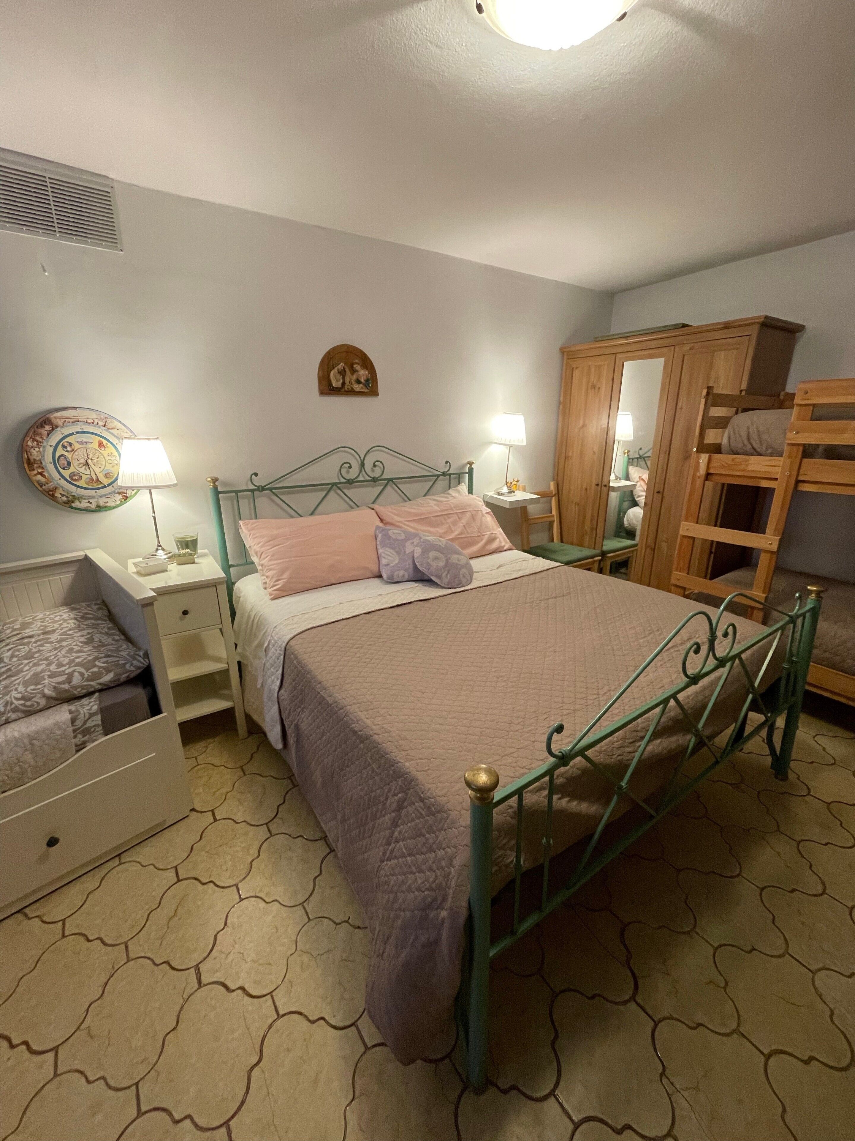 A bedroom with a bed, bedside tables, a wardrobe, and a mirror.