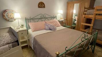 A bedroom with a bed, bedside tables, a wardrobe, and a mirror.