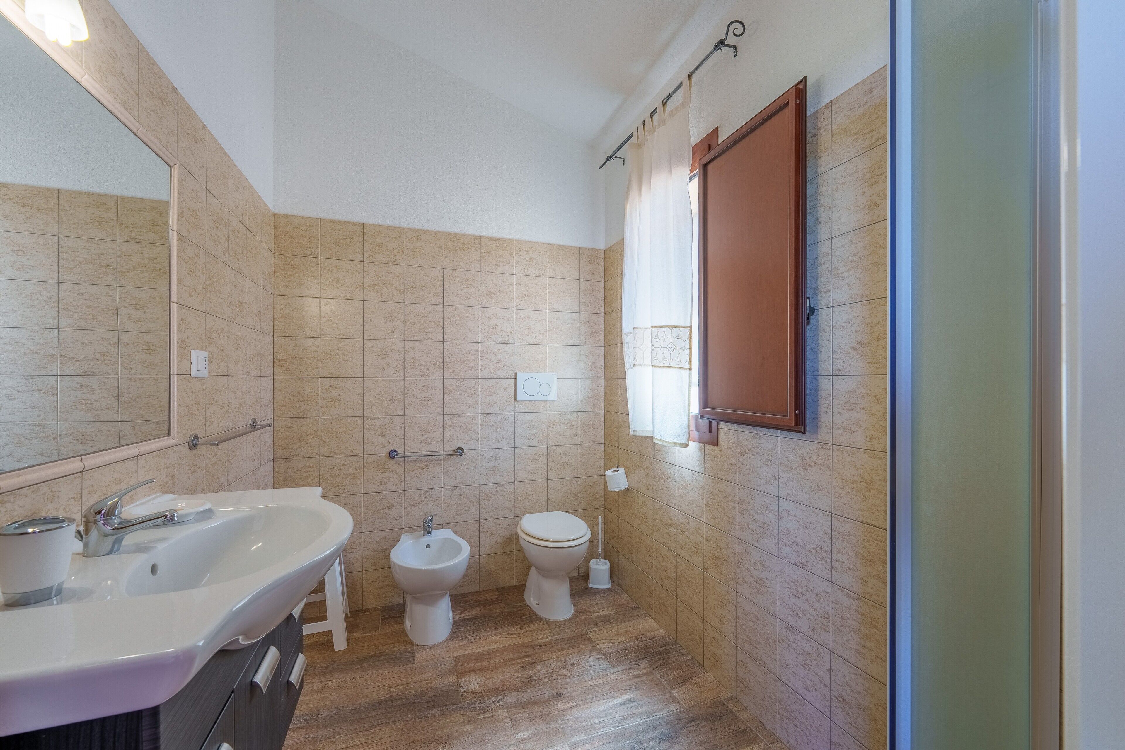 Ein Badezimmer mit Waschbecken, Bidet, Toilette und Spiegel.