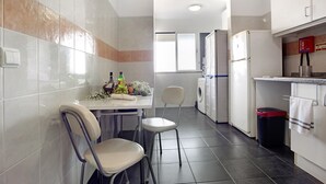 A kitchen with a dining area, a washing machine, and a refrigerator. - Holiday Apartment 'Fénix Garajau' with Sea View, Balcony & Wi-Fi (Caniço)