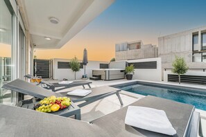 A rooftop pool area with lounge chairs, a hot tub, and a fruit platter. - Apartment Sun Private Pool and Jacuzzi  (Novalja)
