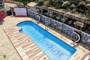 Relax by the pool surrounded by a patterned deck and a charming seating area.