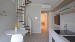 Une cuisine moderne dotée d’une cuisinière intégrée, de meubles blancs et d’un plan de travail en bois.