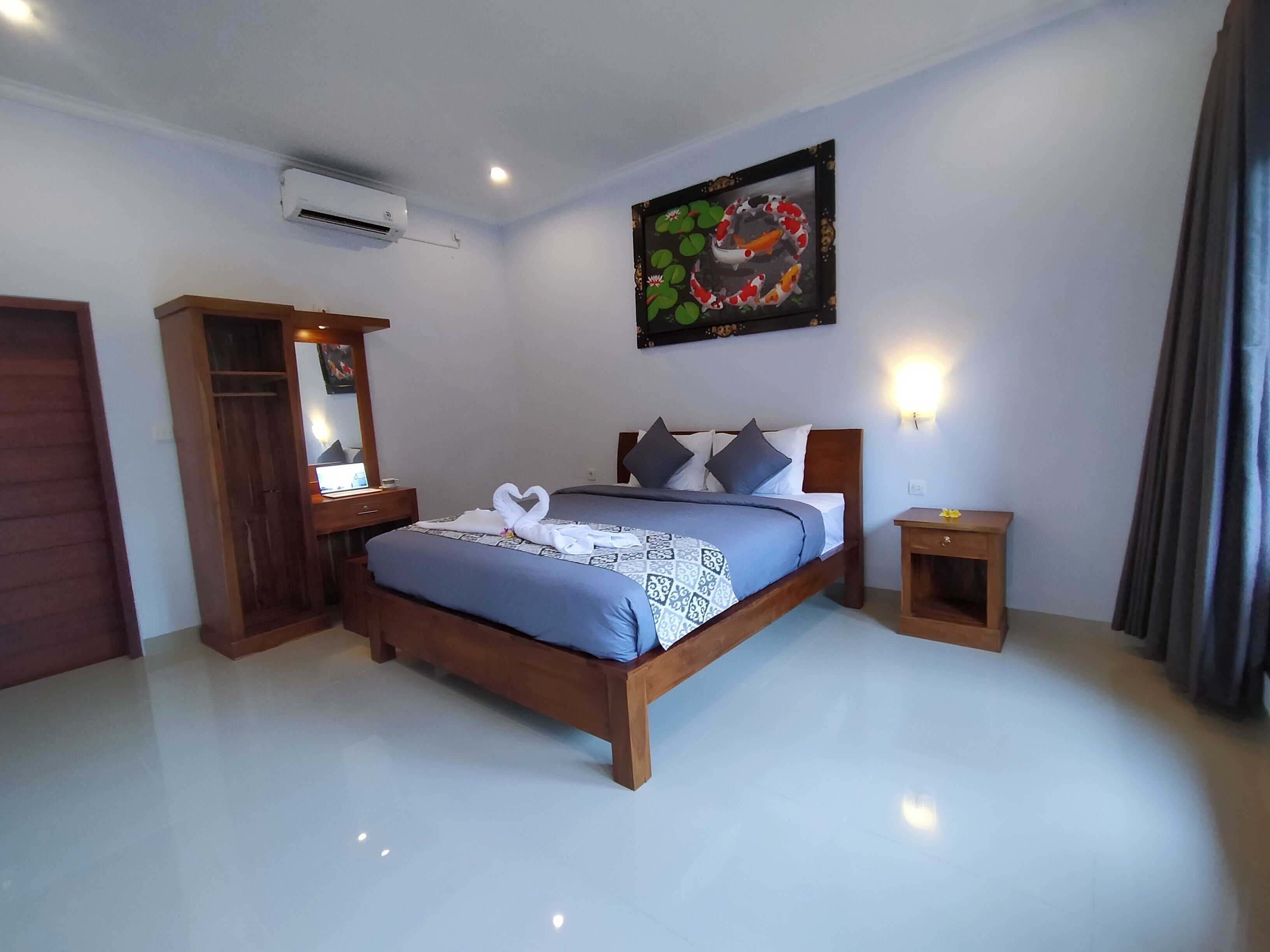 Een slaapkamer met een bed, nachtkastjes, een kledingkast en een schilderij aan de muur.