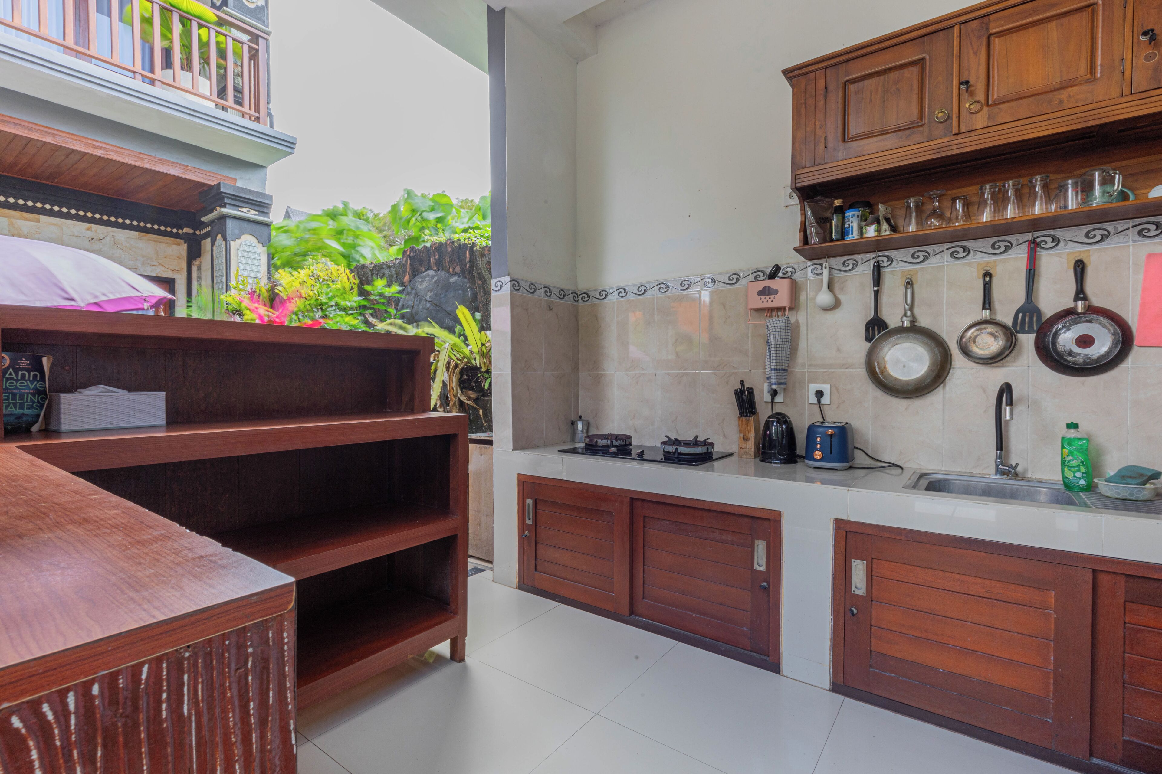 A kitchen with wooden cabinets, a countertop, and a hanging pot rack.