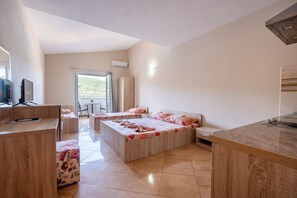 A modern hotel room with a large bed, a desk, and a TV.