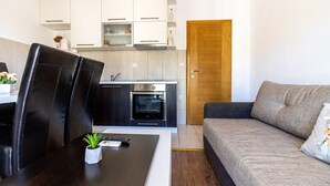 Um espaço compacto com cozinha compacta, área de refeições e sofá.