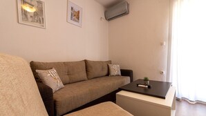 Un salon avec un canapé, une table basse et deux tableaux encadrés accrochés au mur.