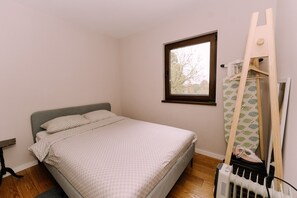 A bedroom with a bed, a window, a radiator, and a wooden ladder. - Holiday Home with private garden and hot tub (Oroslavje)