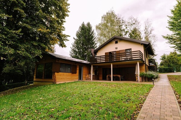 A two-story house with a covered patio and a separate wooden cabin. - Holiday Home with private garden and hot tub (Oroslavje)