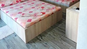 Une petite pièce, de taille modeste, comprenant deux lits, un bureau et une chaise.