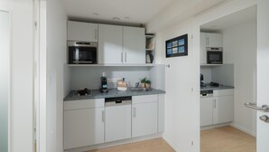 Eine moderne Küche mit weißen Schränken, einem Backofen und einem Geschirrspüler.