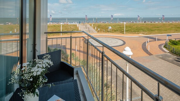 Ein Balkon mit Blick auf den Strand, eine Kreisverkehr und eine Flagge.
