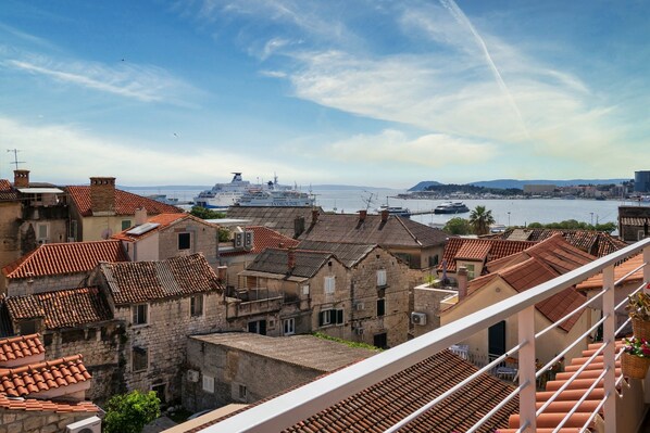 A coastal town with traditional stone buildings and a large cruise ship docked at the harbor.