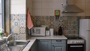 Ett kök med ett mönstrat stänkskydd, en mikrovågsugn, en brödrost, en gasspis och en diskho.
