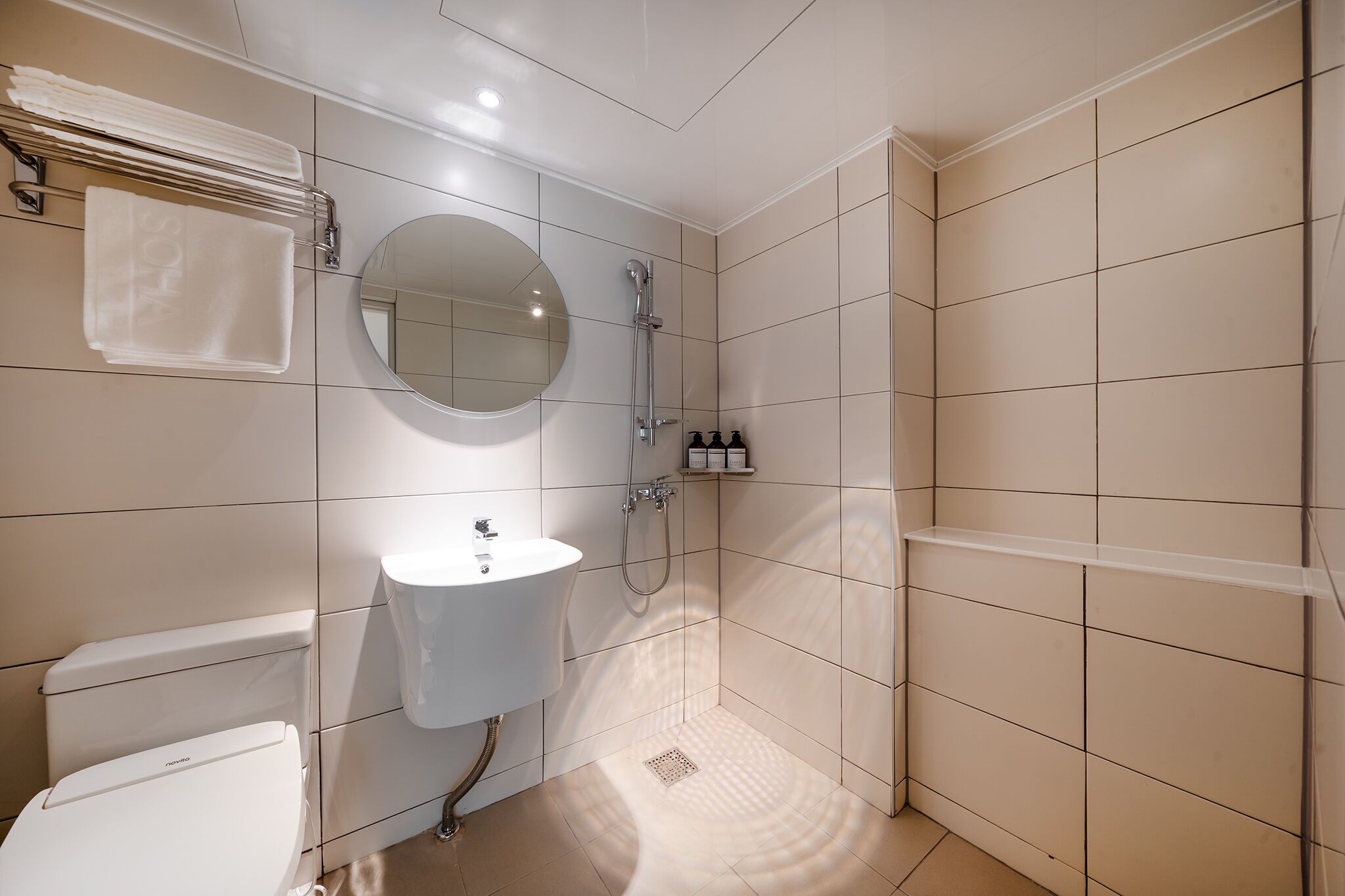 A modern bathroom with a white toilet, sink, and shower.