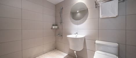 A modern bathroom with a shower, sink, and toilet.
