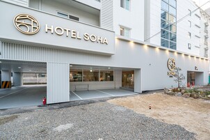 A modern hotel entrance with a prominent sign reading "HOTEL SOHA".