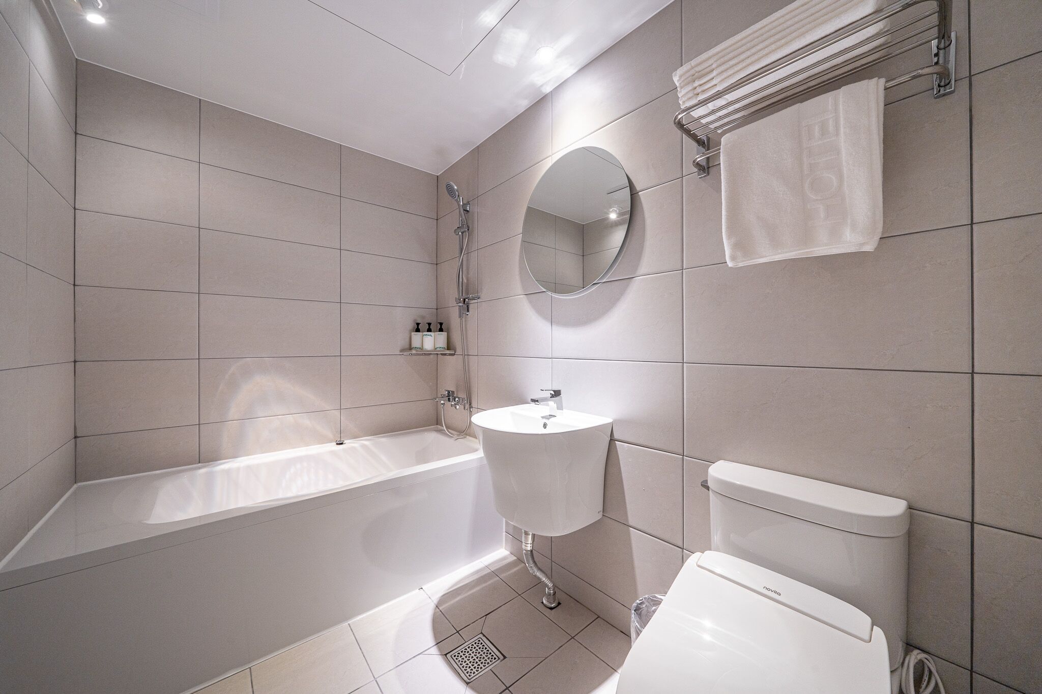 Un bagno moderno con vasca, lavandino, servizi igienici e uno specchio.