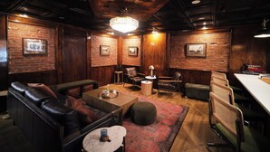 A cozy room with a leather sofa, a small round table, and a patterned rug.