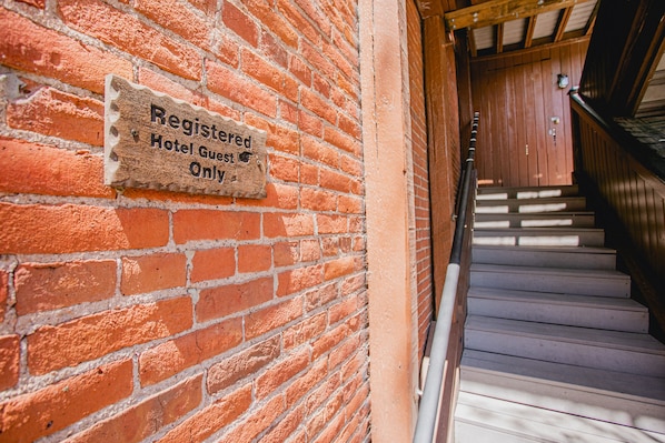 A brick wall with a sign indicating it is for registered hotel guests only.