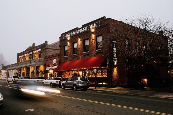 A historic building with a red awning and a sign that reads "Jacksonville Inn." - Experience charming Jacksonville, OR in this 8-bedroom Historic Inn. Enjoy a wine country getaway with 8 private bedrooms. Walk to dining, shopping, and the famed Britt Festival grounds. (Jacksonville)