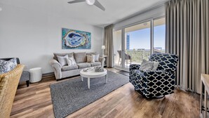 A modern living room with a grey sofa, a patterned armchair, and a coffee table.