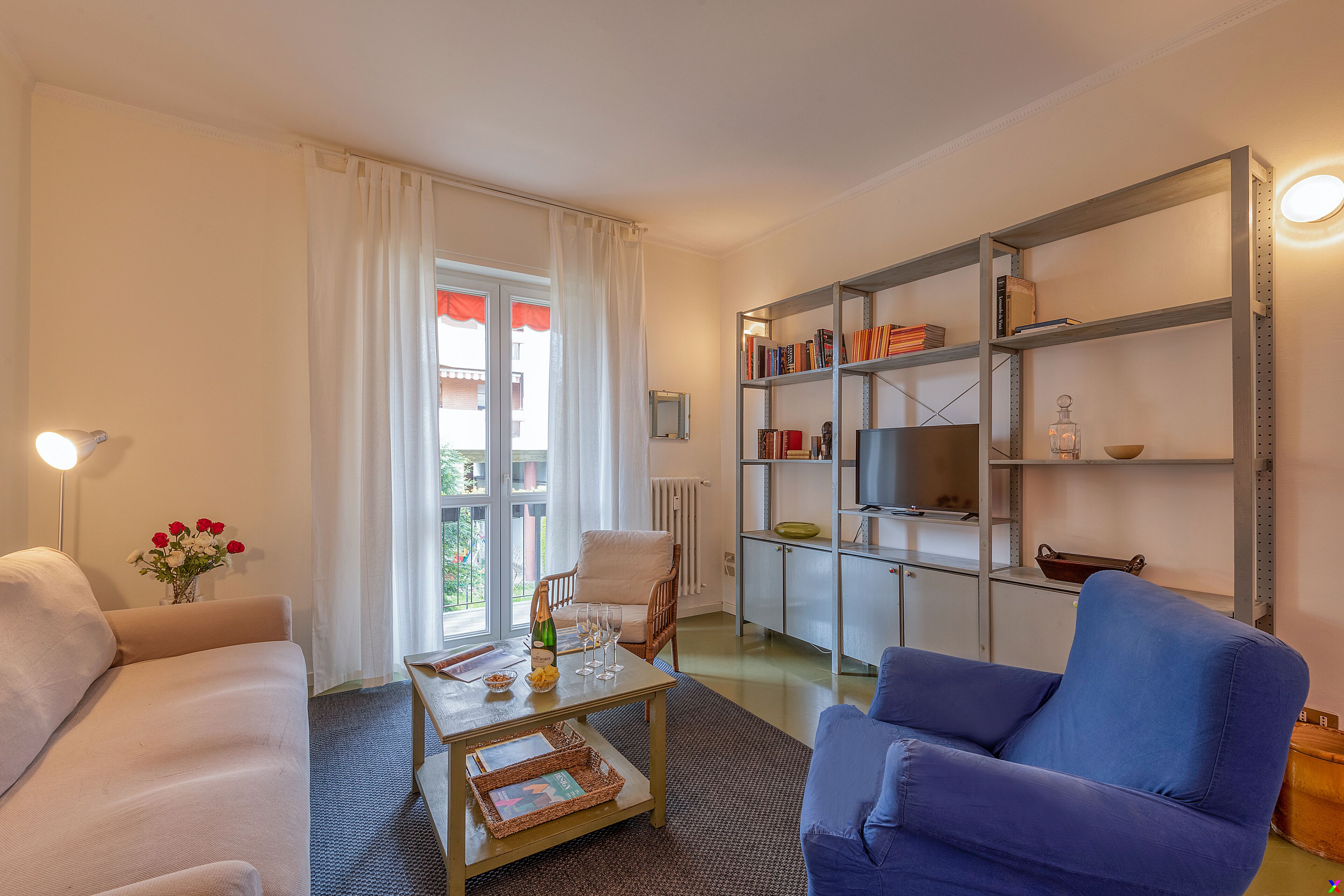 A living room with a sofa, armchair, coffee table, and bookshelf.