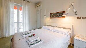 A hotel room with a bed, a bedside table, a lamp, and a painting on the wall. - BnButler - Brivio 21 (Milan)