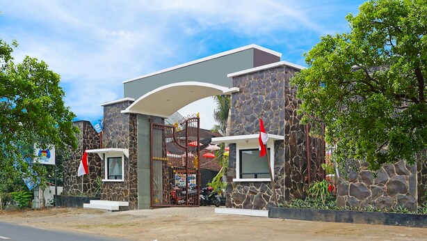 A modern building with a stone facade, a gated entrance, and a small window on the side.