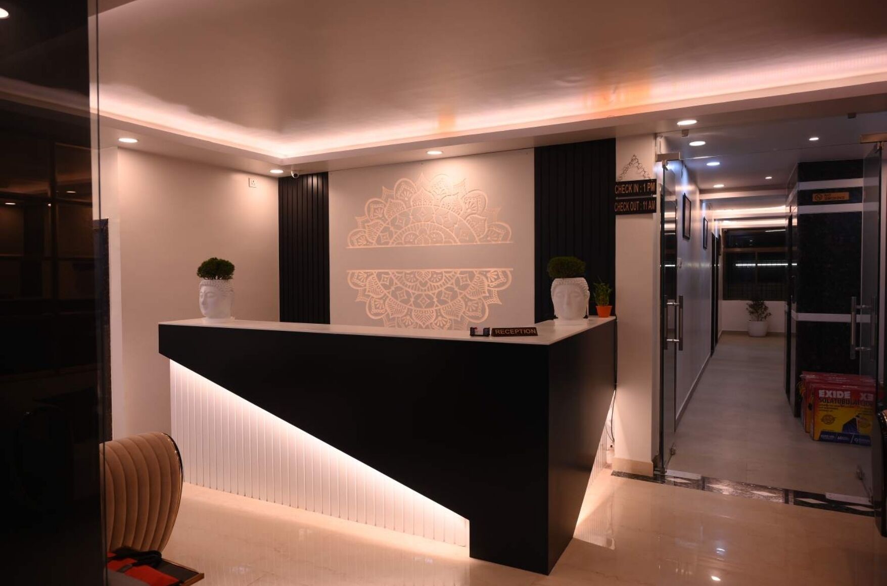 A modern reception desk with a black counter and a decorative wall pattern.