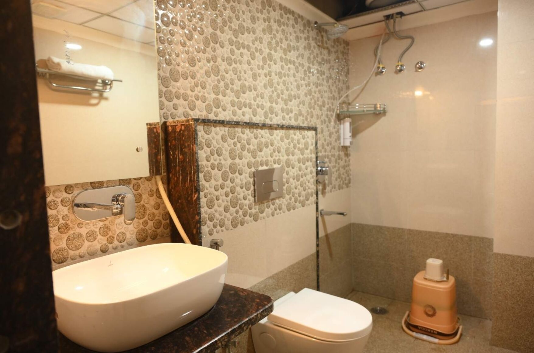 A bathroom with a large sink, toilet, and shower.