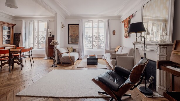 Un salon spacieux avec une cheminée, un piano et un grand miroir.