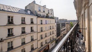 Un immeuble à plusieurs étages doté de balcons, de grandes fenêtres et offrant une vue dégagée sur la rue.