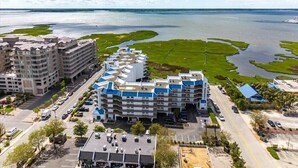 Ett hotell med flera våningar, en parkeringsplats och utsikt över en sjö eller ett annat vattendrag.