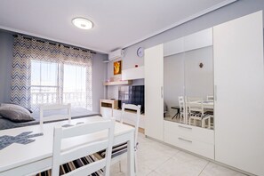 Relax in a bright and airy room with a comfortable bed, dining area, and ample storage.