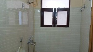 Un baño pequeño con azulejos, un inodoro, una ventana y una ducha.