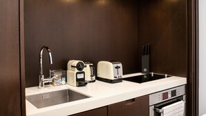 A compact kitchenette with a sink, a coffee maker, a toaster, and a built-in oven. - Appartement Place des lices Avec Parking (Saint-Tropez)