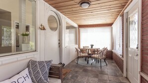 A cozy room with a wooden ceiling, a round table with chairs, a white door, and a window with blinds. - 1500 FT from Gowdy Shores Beach, Fire Pit (Union Pier)