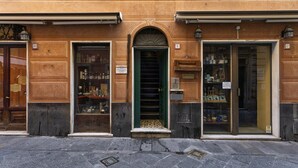A building facade with three storefronts, each with a distinct entrance and signage. - Casa Maril nel Centro Storico di Rapallo by Wonderful Italy (Rapallo)