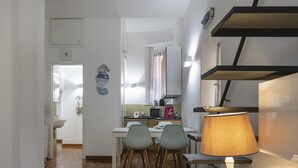 A compact kitchen with a dining area, a microwave, a sink, and a lamp. - Casa Maril nel Centro Storico di Rapallo by Wonderful Italy (Rapallo)